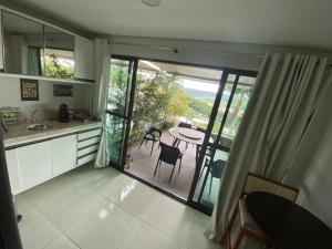 a kitchen with a view of a patio with a table and chairs at Apt Alto da Serra Villas - Bananeiras in Bananeiras