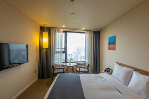 首爾的住宿－JK 花朵飯店，酒店客房配有一张床铺和一张桌子。