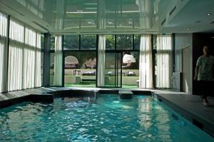 - une piscine dans un bâtiment doté d'une grande fenêtre dans l'établissement Hotel & Spa Le Grand Monarque, BW Premier Collection, à Chartres