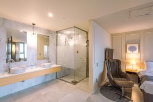 首爾的住宿－JK 花朵飯店，一间带水槽、淋浴和椅子的浴室