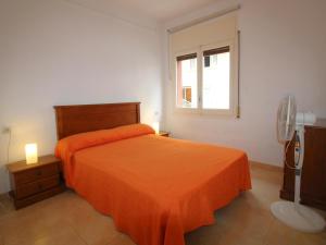- une chambre avec un lit orange et une fenêtre dans l'établissement Apartamento Llançà, 3 dormitorios, 6 personas - ES-228-37, à Llançà