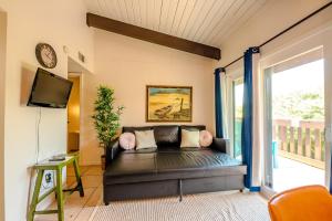 a living room with a couch and a tv at Seagulls Serenade Cozy 1BR Hideaway near Beach 206 in South Padre Island