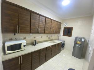 uma cozinha com um micro-ondas e um frigorífico em شقق مساكن الاميره em Iambo