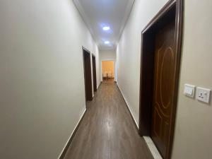un couloir avec parquet et portes dans l'établissement شقق مساكن الاميره, à Yanbu
