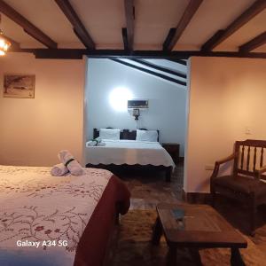 um quarto com uma cama e uma cadeira num quarto em Hostal Rana em Villa de Leyva