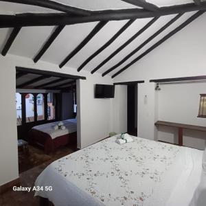sypialnia z 2 łóżkami w pokoju w obiekcie Hostal Rana w mieście Villa de Leyva