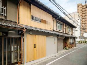 a building with wooden doors on the side of a street at Kotohi Machiya House in Kyoto