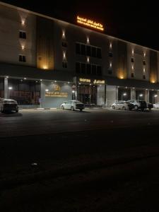 dois carros estacionados em frente a um edifício à noite em شقق درة العريش لشقق المخدومة em Jazan