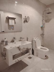 Baño blanco con lavabo y aseo en شقق درة العريش لشقق المخدومة en Jazan