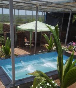 una piscina con tavolo e ombrellone di MARS Jungle Adventure Stud Farm with Private Jacuzzi a Narsinge