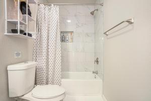 a white bathroom with a toilet and a shower at The Southern Sapphire - A Cozy Lake View Getaway in Granbury +10 photos
