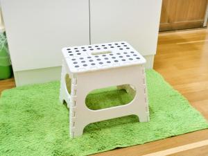 una piccola casa per cani bianca seduta su un tappeto verde di Kokoyui Guest House Shingu - Vacation STAY 03207v a Shingū
