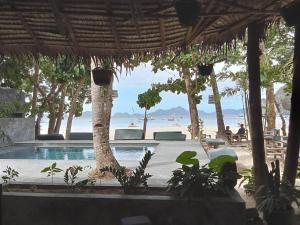 a resort swimming pool with a view of the ocean at La Plage Hotel in El Nido