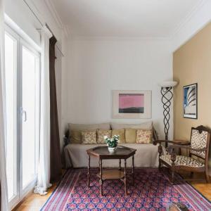 ein Wohnzimmer mit einem Sofa und einem Tisch in der Unterkunft 100m2 of classical beauty comfort near Syntagma in Athen