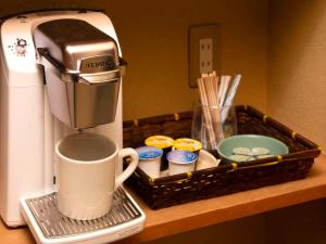 a coffee maker on a counter next to a tray of cupcakes at KKR Yuzawa Yukiguni in Yuzawa