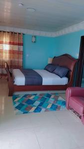 sypialnia z łóżkiem i niebieską ścianą w obiekcie Royal Island Breeze Resort SL w mieście Freetown