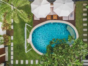 an overhead view of a swimming pool with umbrellas at Aeera Villa Canggu by Ini Vie Hospitality in Canggu