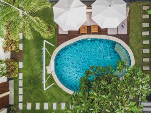 eine Draufsicht auf einen Swimmingpool mit Sonnenschirmen in der Unterkunft Aeera Villa Canggu by Ini Vie Hospitality in Canggu