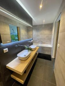 a bathroom with two sinks and a bath tub at Luxury holiday Thatched House In Baarle-Nassau in Baarle-Nassau