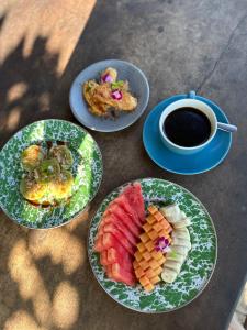 a table with three plates of food and a cup of coffee at Damuh Pertivi, River and Rice Fields View in Lovina +87 photos