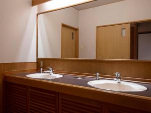 a bathroom with two sinks and a large mirror at KKR Yuzawa Yukiguni in Yuzawa