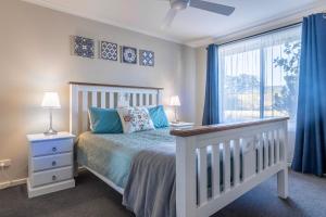 蘇塞克斯入口的住宿－蒂爾海濱度假屋，一间卧室配有床和蓝色窗帘的窗户