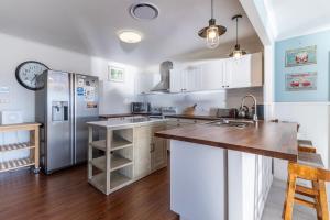 a kitchen with white cabinets and a stainless steel refrigerator at The Waterfront on Teal in Sussex inlet