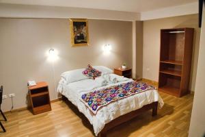 una camera con un letto e due luci accese di Hotel Joram a Cuzco