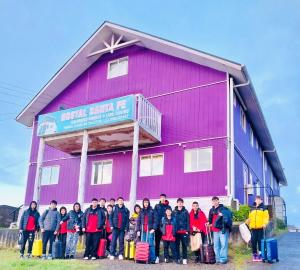 卡斯特鲁Hostal Santa Fe的一群站在粉色建筑前面的人