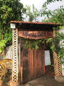 un ingresso a un cancello in legno con una ruota di legno di Ingawale farmhouse (agro tourism) a Satara