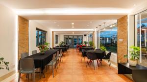 a dining room with black tables and chairs at California Hotel in Da Lat