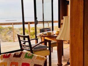 ein Esszimmer mit Tisch und Blick auf das Meer in der Unterkunft IdleWild - Secluded Absolute Beachfront Escape in Dolphin Sands