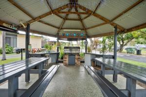 a picnic shelter with benches and a grill at Tasman Holiday Parks - Fisherman's Beach in Emu Park