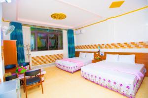 a bedroom with two beds and a table and chairs at Hưng Hà Hotel DB - by BAY LUXURY in Diện Biên Phủ