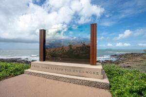 a picture of a painting on a sign next to the ocean at Tasman Holiday Parks - Fisherman's Beach in Emu Park +9 photos