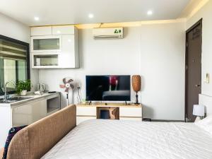 a bedroom with a bed and a tv and a kitchen at Green Line Long Bien - Serviced Apartment - Ngoc Thuy - Hanoi in Hanoi