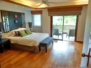 ein Schlafzimmer mit einem Bett und einem Balkon in der Unterkunft Laguna Park Townhomes & Villas in Strand Bang Tao