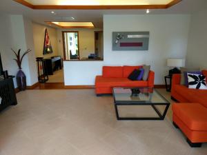 a living room with an orange couch and a table at Laguna Park Townhomes & Villas in Bang Tao Beach