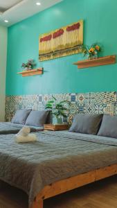 Cama grande en habitación con pared azul en Simi Homestay en Vung Tau