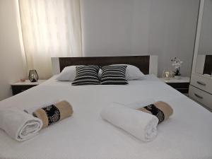 białe łóżko z ręcznikami i poduszkami w obiekcie Blanca w mieście Kaštela