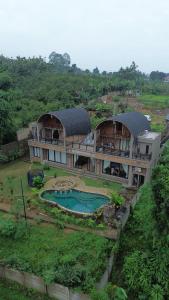 a large house with a pool in front of it at Villa Sasandu Termanu in Gadog