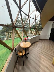 a room with a table and chairs in a building with windows at Superb Romantic DOME Villeta Hot Tub Only 4x4 or motorbike in Villeta