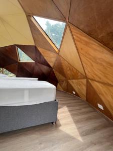 a bedroom with a bed and a wall of wood panels at Superb Romantic DOME Villeta Hot Tub Only 4x4 or motorbike in Villeta
