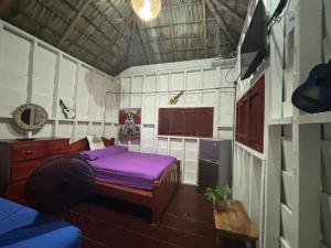 Kleines Zimmer mit einem lila Bett. in der Unterkunft Sea la vie casita in Las Peñitas