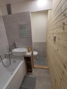 ein Badezimmer mit einem Waschbecken, einer Badewanne und einem WC in der Unterkunft Apartmán Brno-Bystrc in Brünn