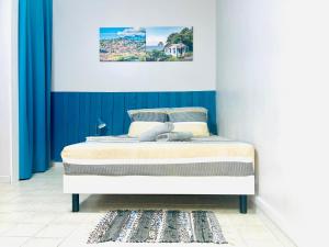 a bed in a room with a blue and white wall at Belle vue in Fort-de-France