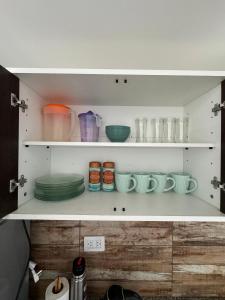 a white shelf with bowls and plates on it at Rincón Montañas del Sur in Ushuaia