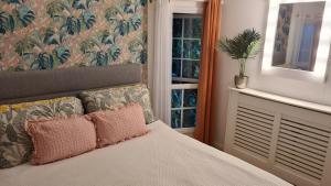 ein Schlafzimmer mit einem Bett und ein Fenster mit einer Pflanze in der Unterkunft Sunset View in Gillingham