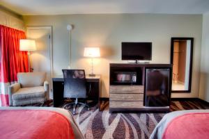 a hotel room with a bed and a desk and a television at The Beaucatcher, a Boutique Motel in Asheville
