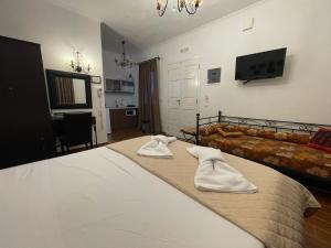 a bedroom with a bed with two white towels on it at Alice Maisonette & Studios in Adamantas